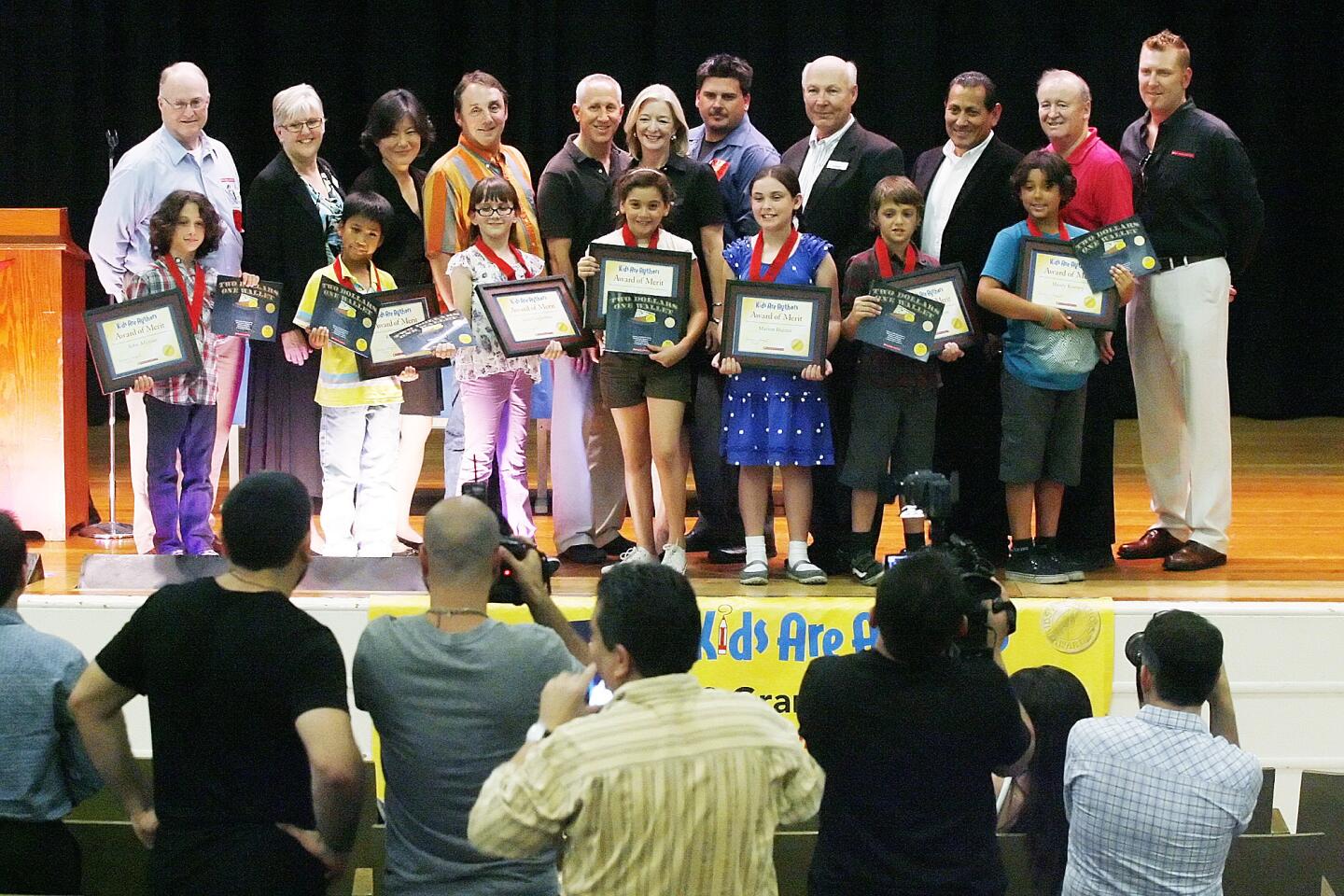 The seven third grade authors, of John Alajijian, Russell Uvas, Julia Guglielmo, Sara Cohen, Marion Hunter, Noel Pennington and Henry Keeney, stand with Scholastic Book Fairs representatives on stage for photos at McKinley Elementary School in Burbank on Thursday, September 20, 2012. Seven third grade students, with the help of a parent coordinator, wrote the book Two Dollars One Wallet which won the Scholastic Book Fairs Kids Are Authors 2012 National Fiction Grand Prize Award.