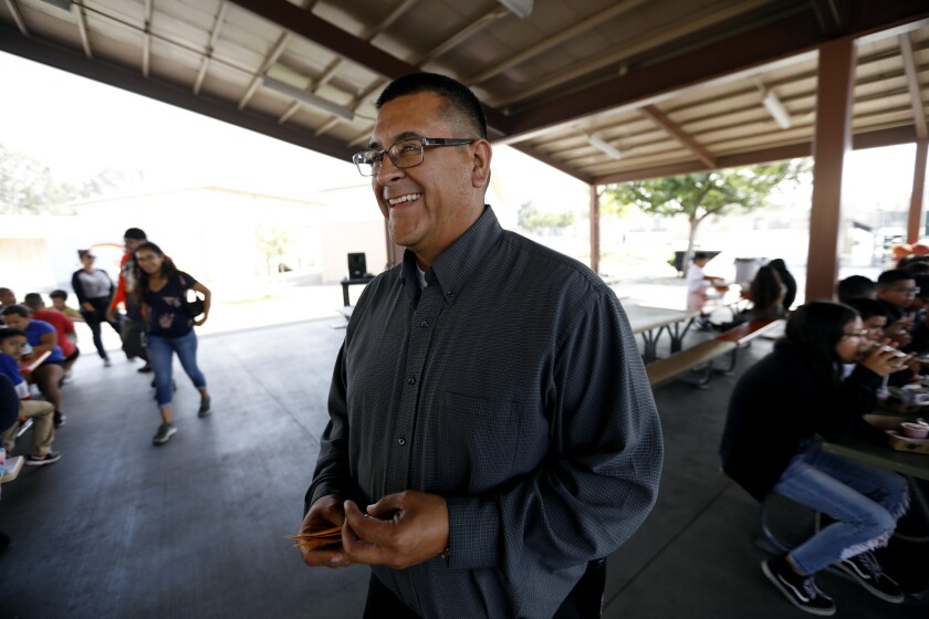 Telfair Elementary School Principal Jose Razo smiles as he talks with students and helps clean up during lunch hour.