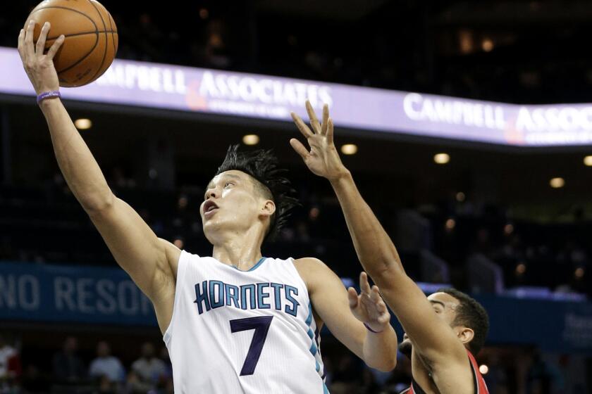 Hornets guard Jeremy Lin drives past Raptors guard Cory Joseph for a layup.