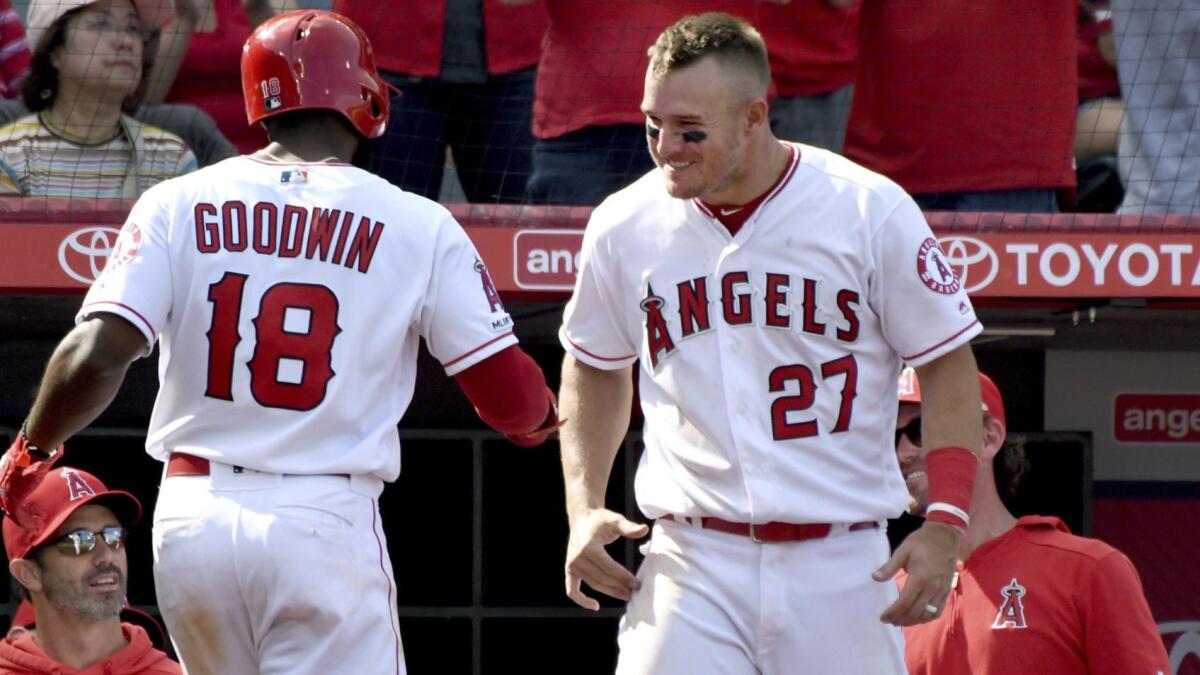 Angels slugger Mike Trout (27) congratulates teammate Brian Goodwin after he hit a solo home run Sunday.