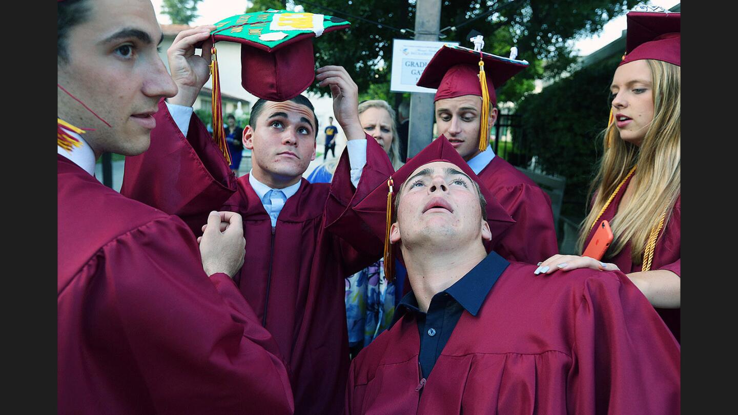 La Cañada High School's Theo Chamberlain, 17, with a group of friends, bends back to show the top of his graduation cap to parent Sonja Bradley (in the background) at the annual Interfaith Baccalaureate Service at St. Bede the Venerable in La Cañada Flintridge on Tuesday, May 30, 2017. The student attendance was mostly graduating seniors from La Cañada High School, but was open to all.