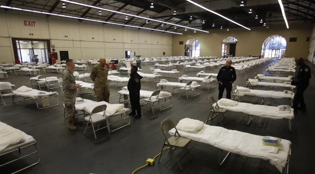 Cots are set up at a possible coronavirus treatment site April 1 in San Mateo, Calif. The National Guard is setting up the federal cache, which includes cots and personal protective equipment needed to establish a federal medical station with capacity up to 250 beds.