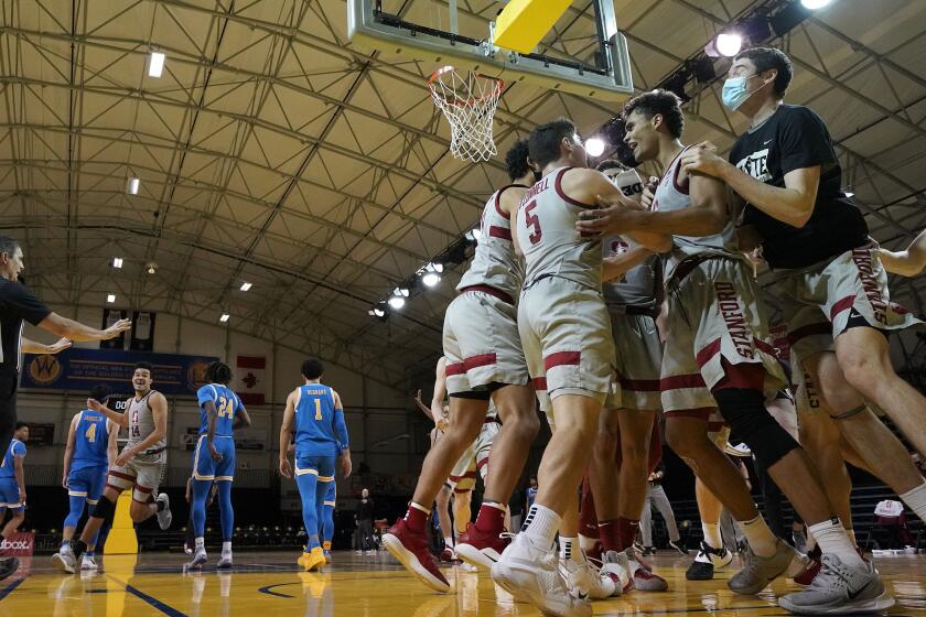 Stanford's Oscar da Silva, second from right, celebrates with teammates after his game-winning shot Jan. 23, 2021.