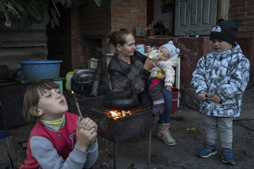 Margaryta Tkachenko, 29 years old, feeds her 9-month-old daughter Sophia in the recently retaken town of Izium, Ukraine, Sunday, Sept. 25, 2022. (AP Photo/Evgeniy Maloletka)
