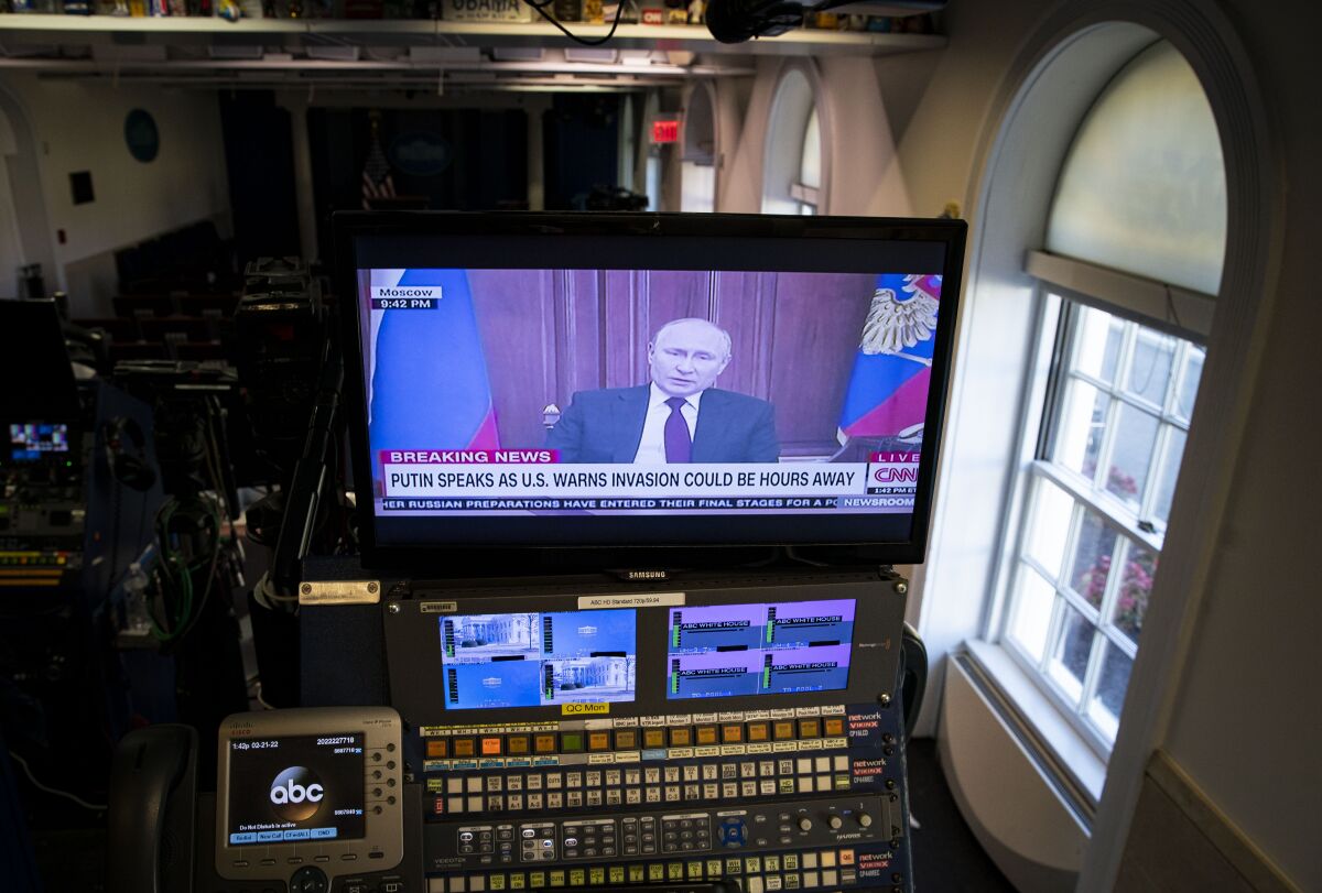 A TV screen shows a man speaking on a CNN broadcast 