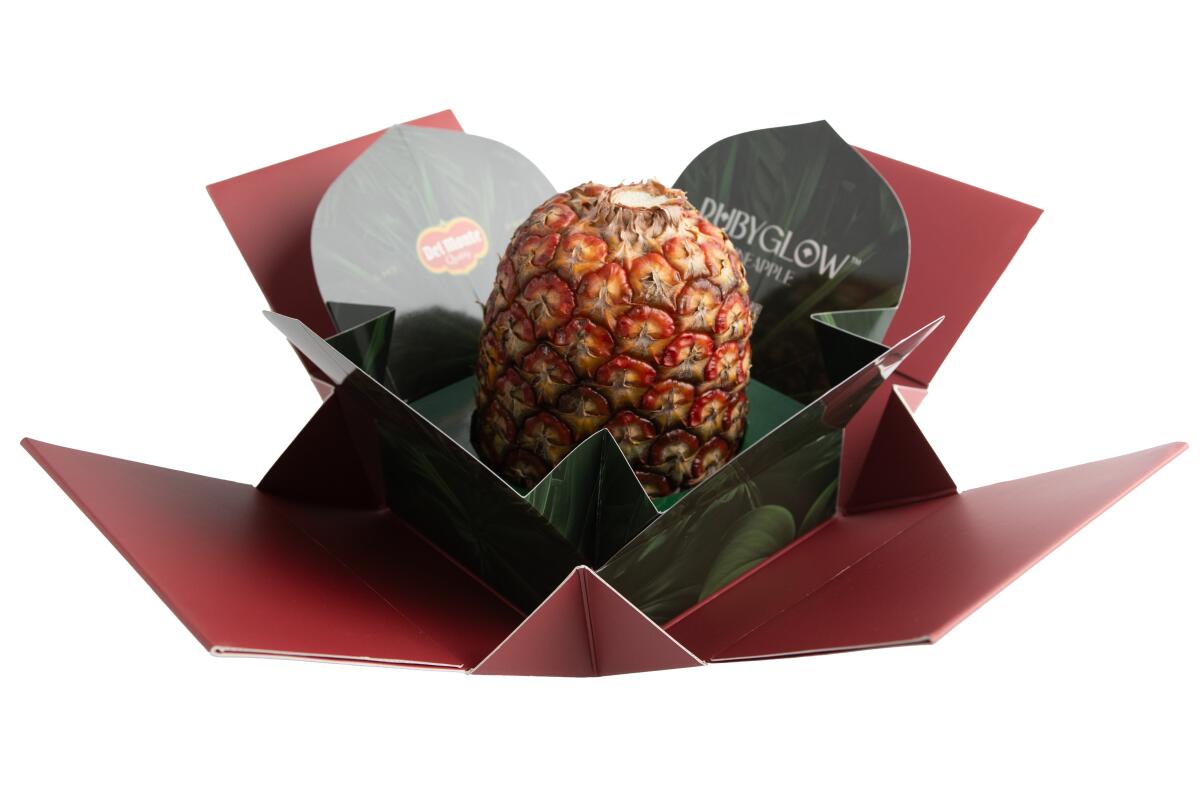 The $395.99 Ruby Glow pineapple framed by its opened packaging