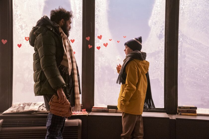 A man and a little girl standing before a frosted window with hearts on it
