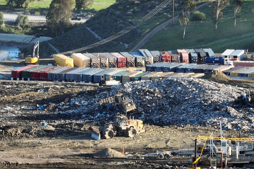 Castaic, CA - February 22: An aerial view of heavy equipment spreading trash over a hill and roughly 100 metal storage containers storing contaminated or polluted water, holding up to 20,000 gallons each as the result of an underground landfill fire at Chiquita Canyon Landfill in Castaic Thursday, Feb. 22, 2024. Around 200,000 gallons of the contaminated water is coming out of the landfill each day. Environmental regulators have found elevated levels of cancer causing Benzine in the polluted water spilling onto the surface of the landfill. Landfill operators are also constructing a drainage system to capture the contaminated water that is spilling onto the surface and proactively pumping the water. Residents of Val Verde and Castaic are protesting to call for Chiquita Canyon Landfill to be closed in Hasley Canyon Park in Castaic. Garbage has been burning deep inside the landfill due to a chemical reaction for much of the past year, and recently scalding-hot contaminated water has surged to the surface. The protest follows calls from the County Supervisor Kathryn Barger's office, which said the landfill should provide funds to relocate residents who want to temporarily move until the issue is resolved. (Allen J. Schaben / Los Angeles Times)