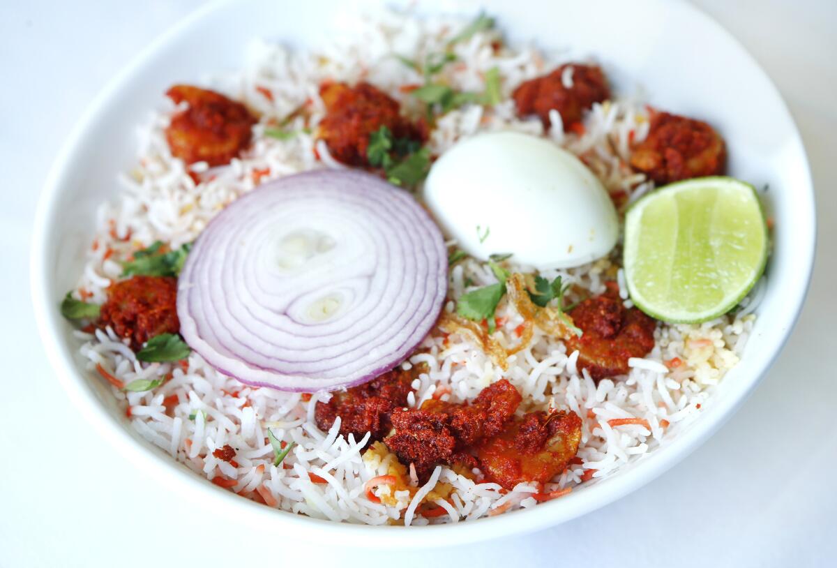 Shrimp Biryani, consisting of basmati rice, red onion, hard boiled egg, lime, cilantro, and medium breaded shrimp, is on the menu at Paradise Biryani Pointe.