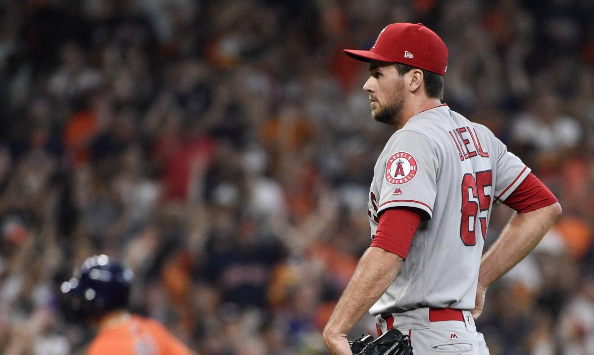 Angels relief pitcher Jake Jewell, right, backs off the mound as Houston's Aledmys Diaz rounds the bases