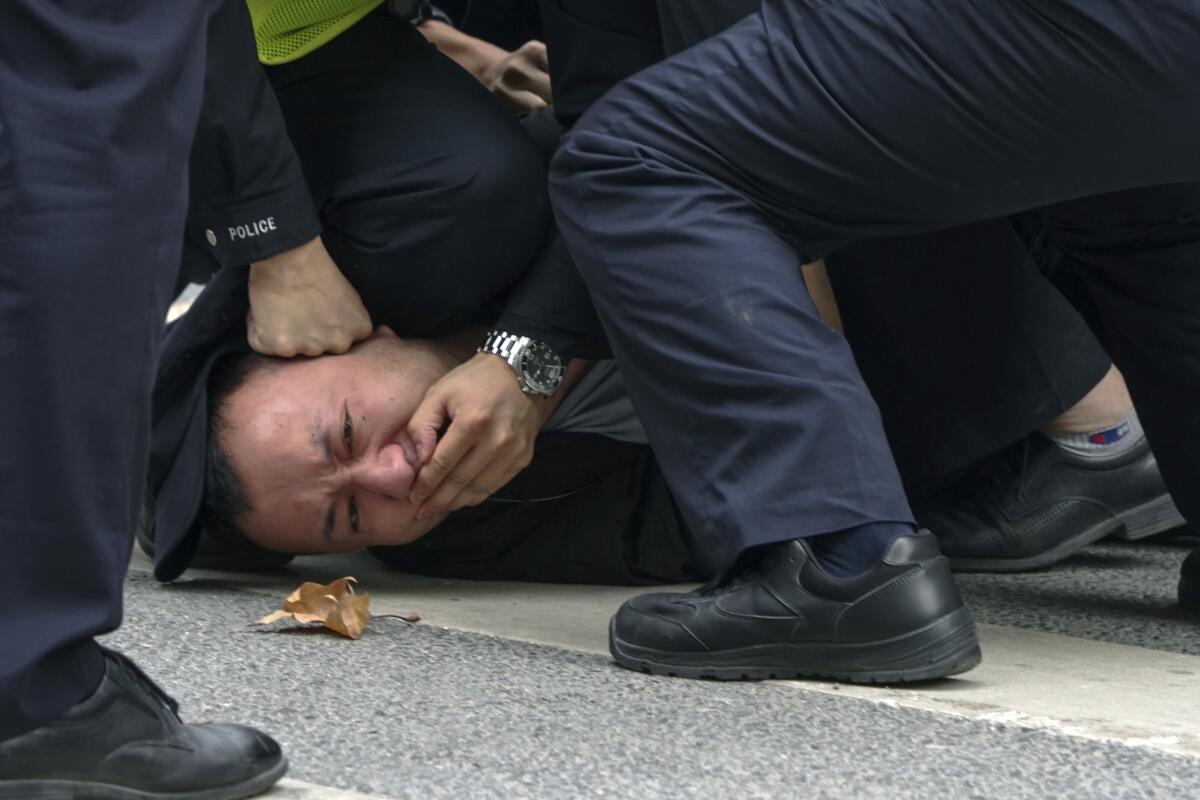 Protester being pinned to ground by police in Shanghai