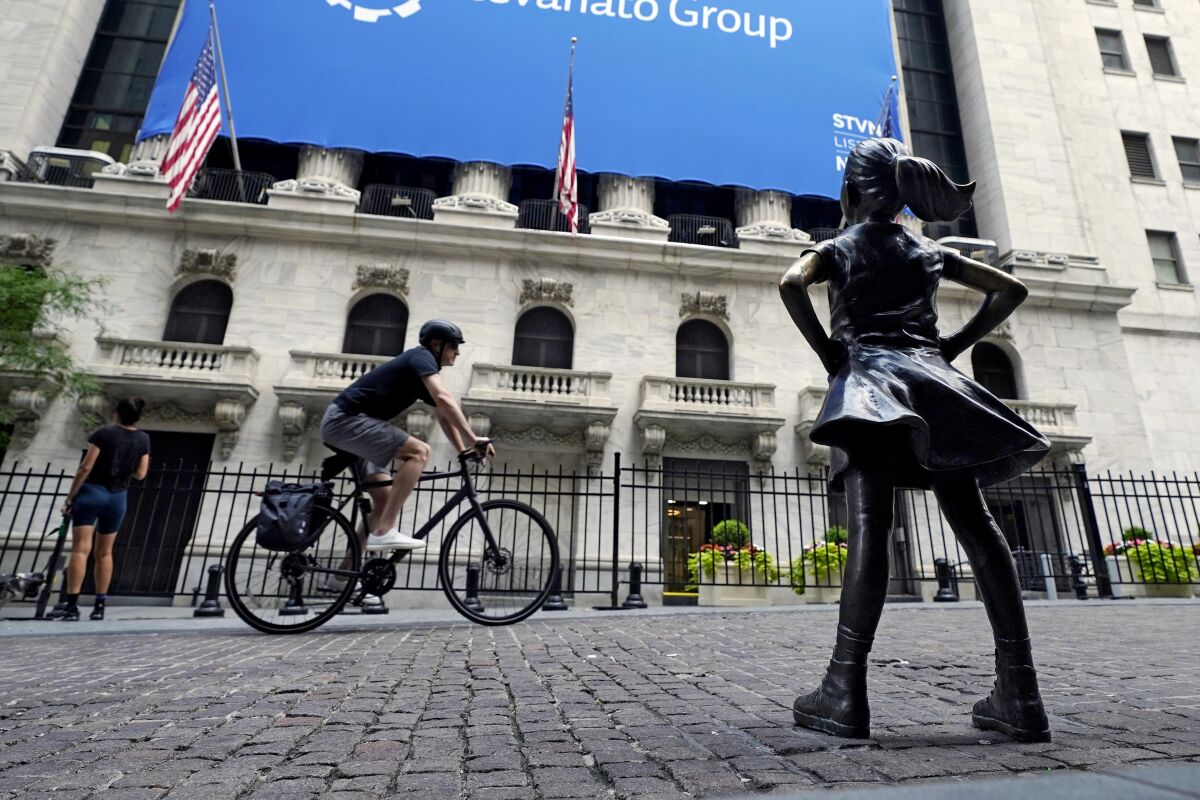 FILE - The Fearless Girl statue faces the New York Stock Exchange, Tuesday, July 20, 2021. Stocks are off to a mixed start on Wall Street, Friday, Aug. 13 as gains for communications and health care companies are checked by weakness in energy and other sectors. (AP Photo/Richard Drew)