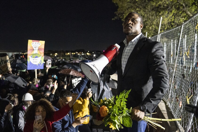 Michael Odiari leads a chant as he attempts to deescalate an altercation between demonstrators and police during a protest decrying the shooting death of Daunte Wright outside the Brooklyn Center Police Department, Friday, April 16, 2021, in Brooklyn Center, Minn. (AP Photo/John Minchillo)