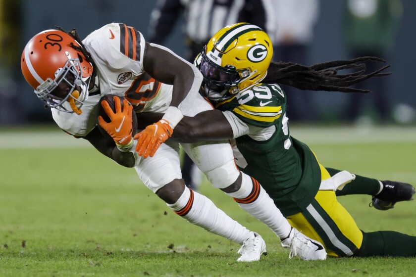 FILE - Green Bay Packers' De'Vondre Campbell, right, stops Cleveland Browns D'Ernest Johnson (30) during the second half of an NFL football game Dec. 25, 2021, in Green Bay, Wis. Packers linebacker Campbell remembers every critical comment he received after fighting through nagging injuries while playing for the Arizona Cardinals last season. (AP Photo/Matt Ludtke, File)