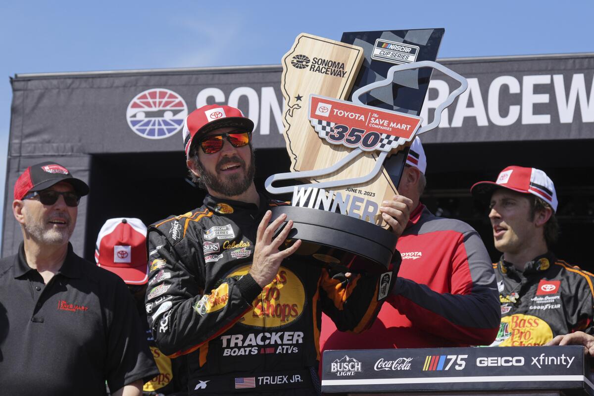NASCAR driver Martin Truex Jr. holds the trophy after winning a NASCAR Cup Series race at Sonoma Raceway on Sunday.