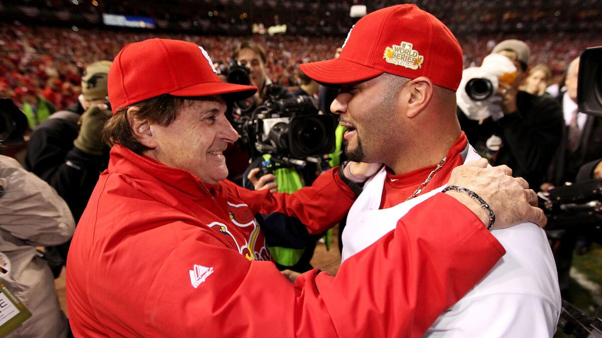 St. Louis Cardinals Manager Tony La Russa, left, speaks with first baseman Albert Pujols after the team's 2011 World Series win over the Texas Rangers.