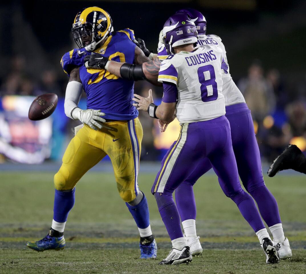 Los Angeles Rams defensive tackle Michael Brockers, left, forces a fumble by Minnesota Vikings quarterback Kirk Cousins during the second half in an NFL football game Thursday, Sept. 27, 2018, in Los Angeles. (AP Photo/Jae C. Hong)