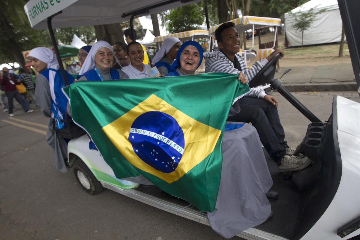 Nuns hold up a Brazilian flag as they ride through Quinta da Boa Vista park in Rio de Janeiro.