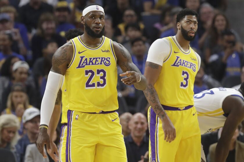 Los Angeles Lakers forward LeBron James (23) reacts in front of forward Anthony Davis (3) during the first half of a preseason NBA basketball game against the Golden State Warriors in San Francisco, Saturday, Oct. 5, 2019. (AP Photo/Jeff Chiu)