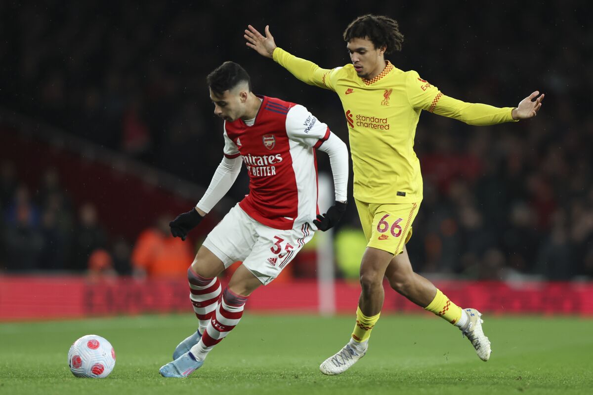 Arsenal's Gabriel Martinelli, left, and Liverpool's Trent Alexander-Arnold battle for the ball during the English Premier League soccer match between Arsenal and Liverpool at Emirates Stadium in London, Wednesday, March 16, 2022. (AP Photo/Ian Walton)