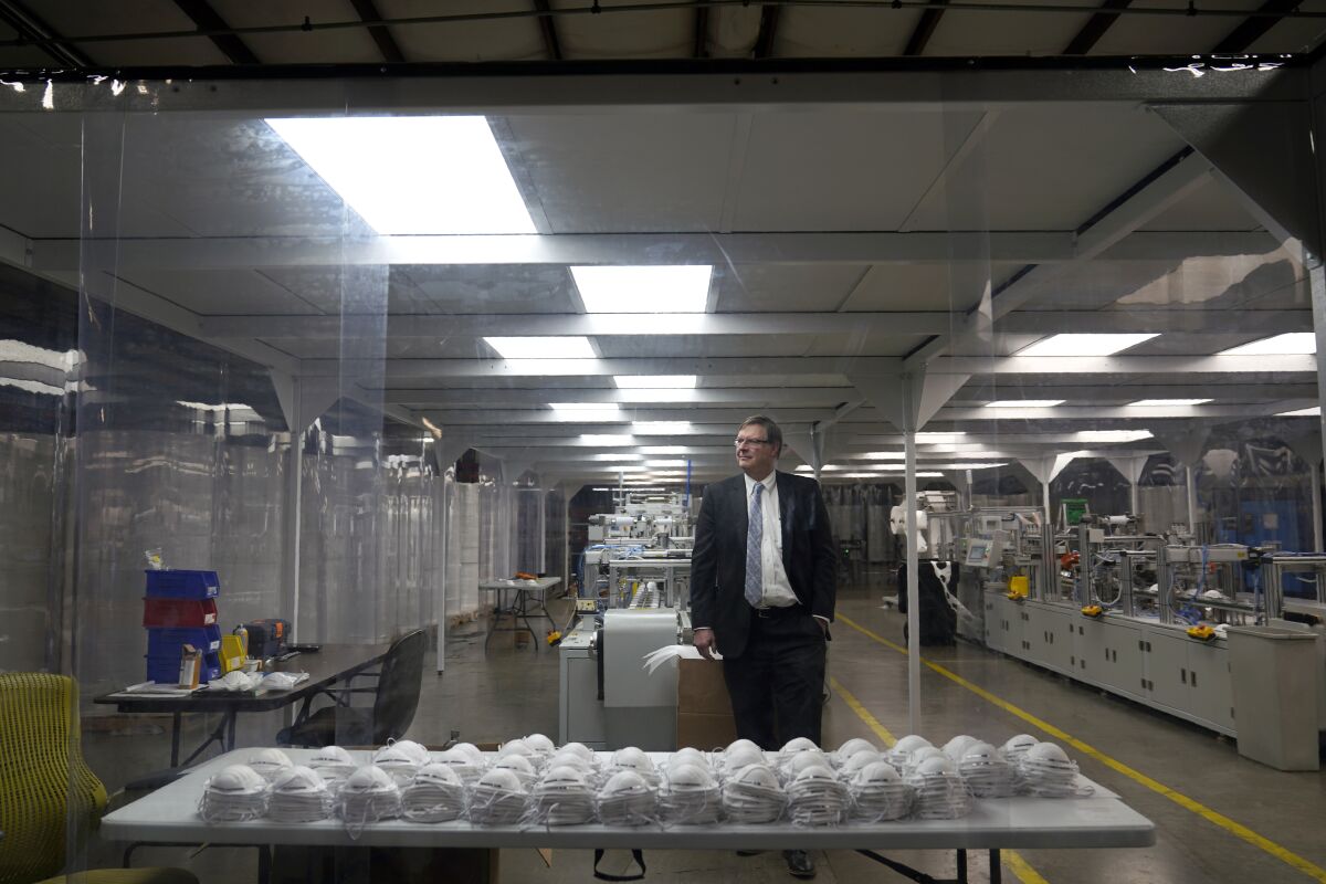 Jim Schmersahl, owner of Halcyon Shades, poses in a "clean room" used in making N-95 masks at the company's production facility Friday, March 18, 2022, in University City, Mo. Halcyon is small company that normally makes window shades, but when the pandemic hit, its sales plummeted. Halcyon applied for the state grants to make PPE as a way to try to keep its employees at work and keep the company afloat. (AP Photo/Jeff Roberson)