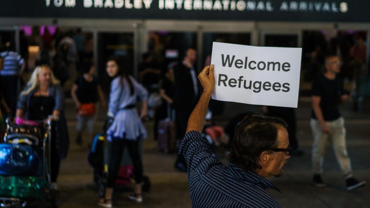 An activist shows his support for refugees at Los Angeles International Airport hours before the travel ban went into effect on June 29.