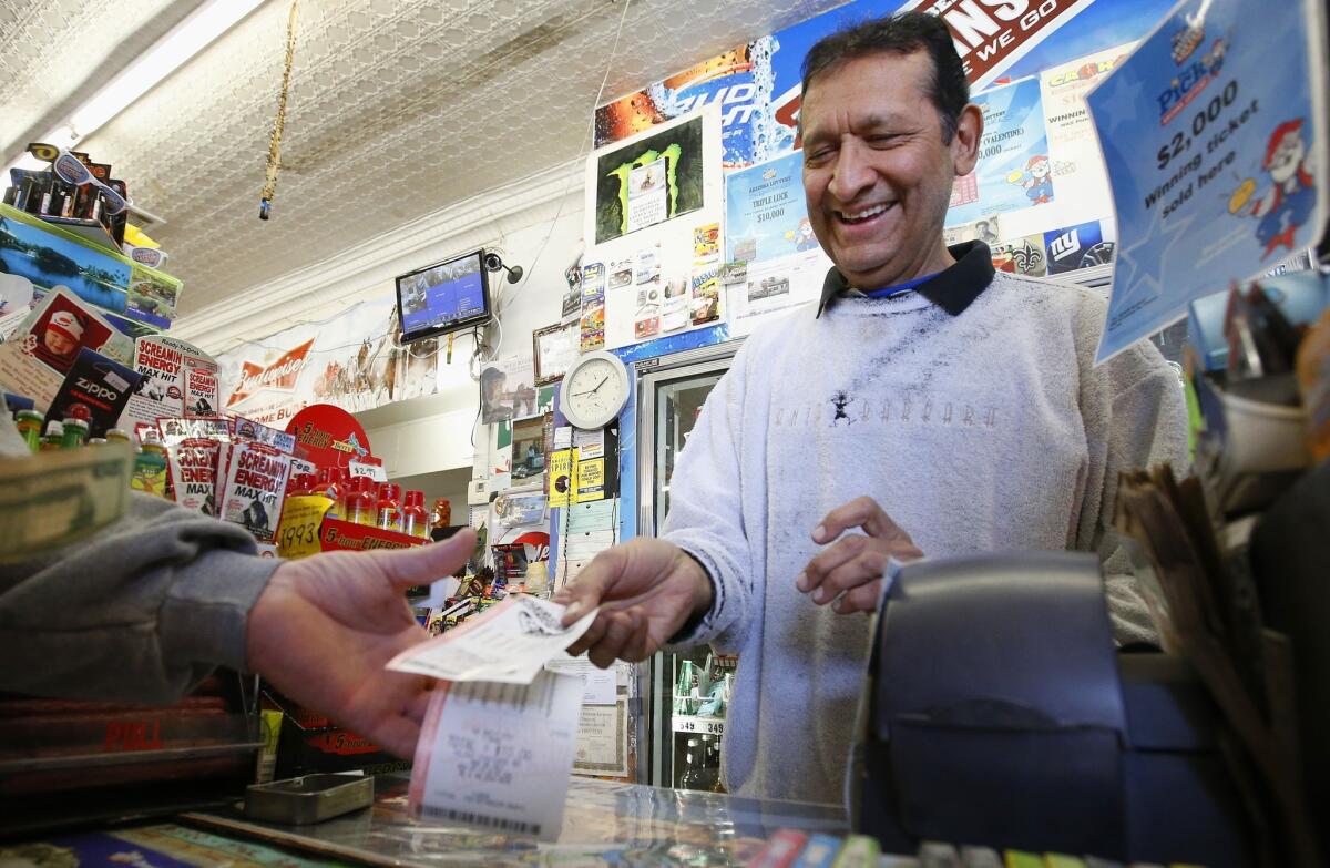 Keith Ganatra, owner of Del Monte Market in Laveen, Ariz., sells lottery tickets at a brisk pace Tuesday.