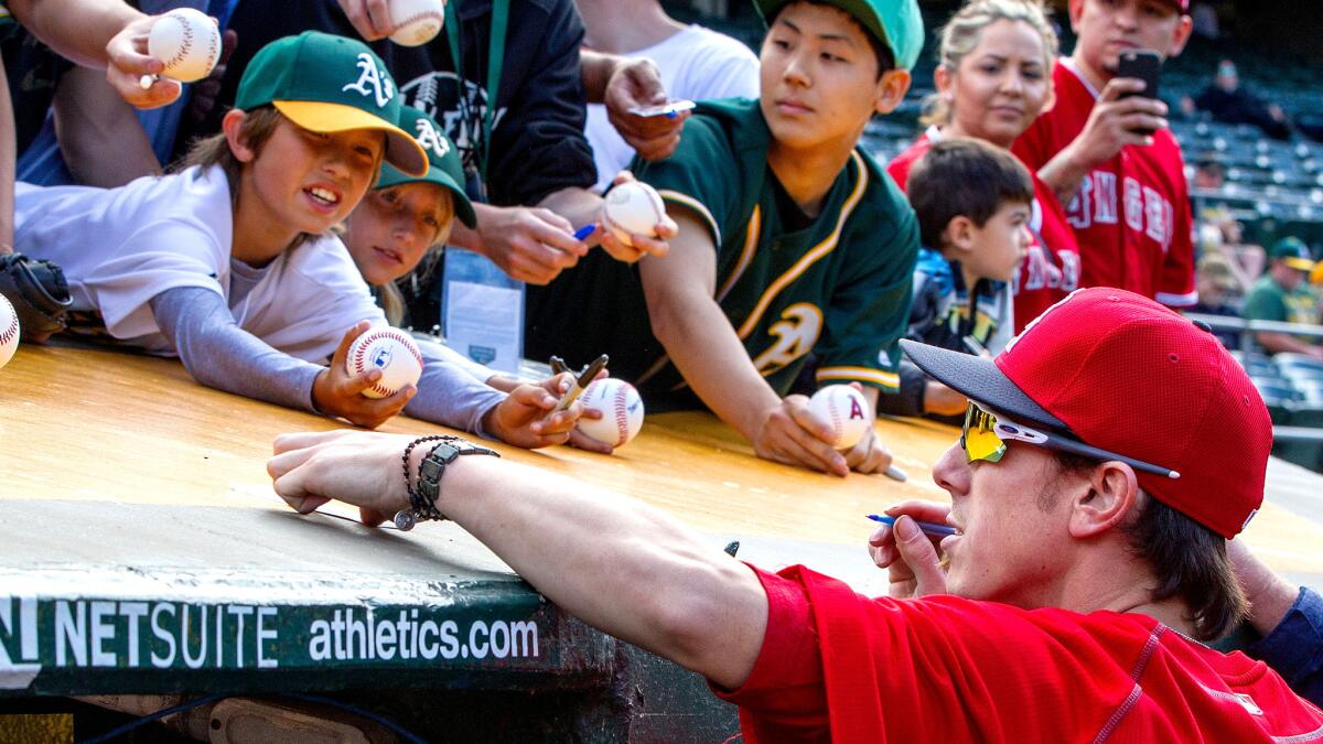 Angels pitcher Tim Lincecum signs autographs before a game against the Athletics on Friday night in Oakland.