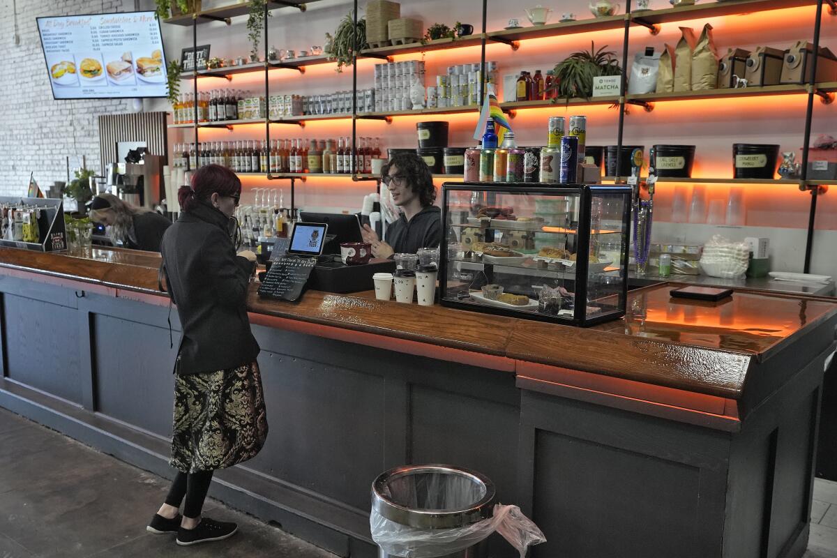ARCHIVO - Una clienta compra un café en el Blind Tiger Cafe 