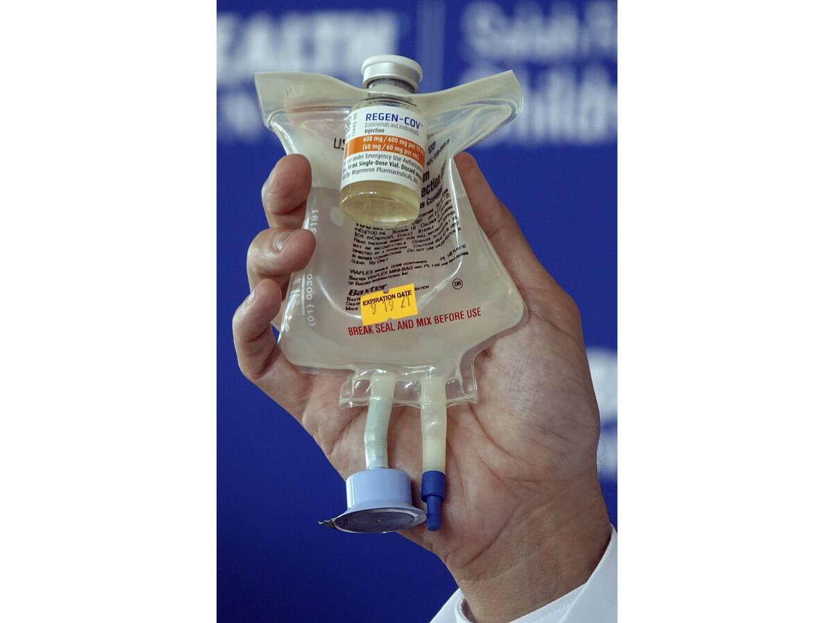 A hand holds a Regeneron monoclonal antibody infusion bag
