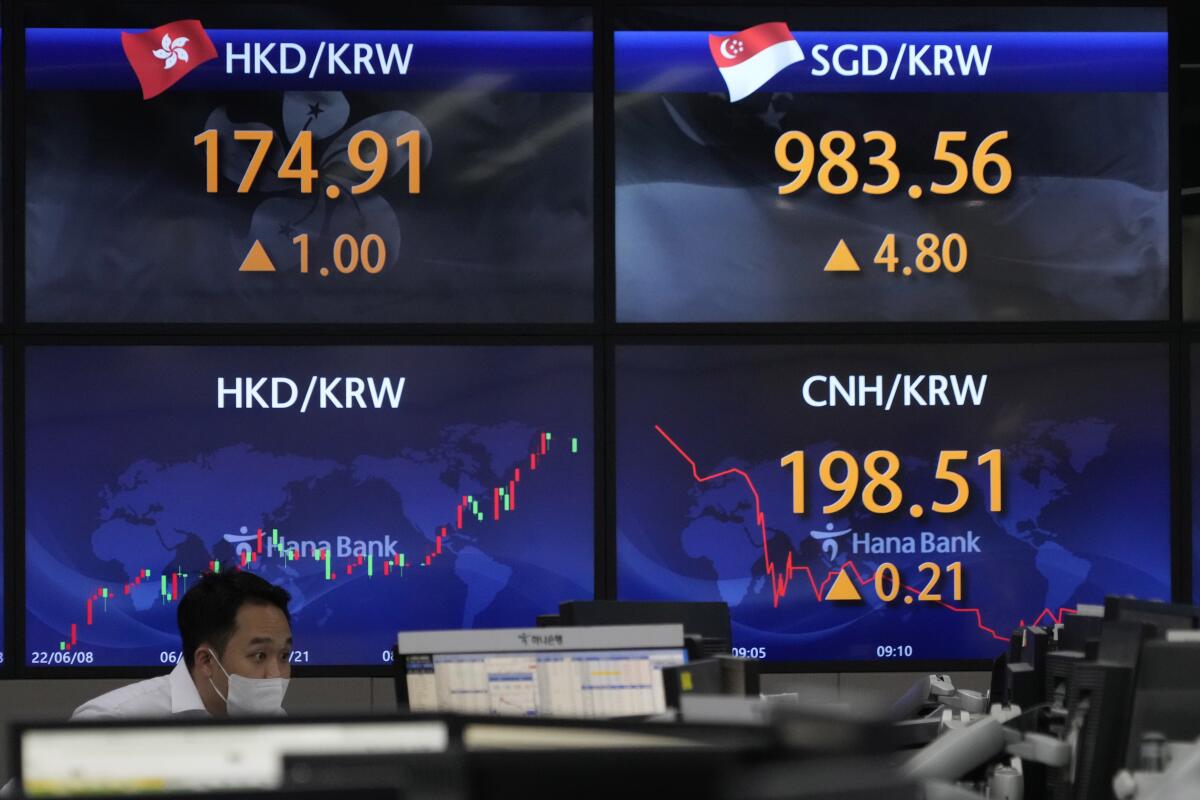 A currency trader watches computer monitors near the screens showing the foreign exchange rates at a foreign exchange dealing room in Seoul, South Korea, Tuesday, Sept. 13, 2022. Asian stocks followed Wall Street higher on Tuesday ahead of data traders hope will show surging U.S. inflation eased in August, reducing pressure for more interest rate hikes. (AP Photo/Ahn Young-joon)