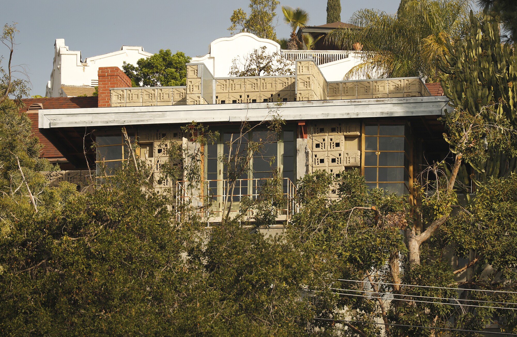 The sun shines on the textile-block front facade of Frank Lloyd Wright's Freeman House in the Hollywood HIlls.