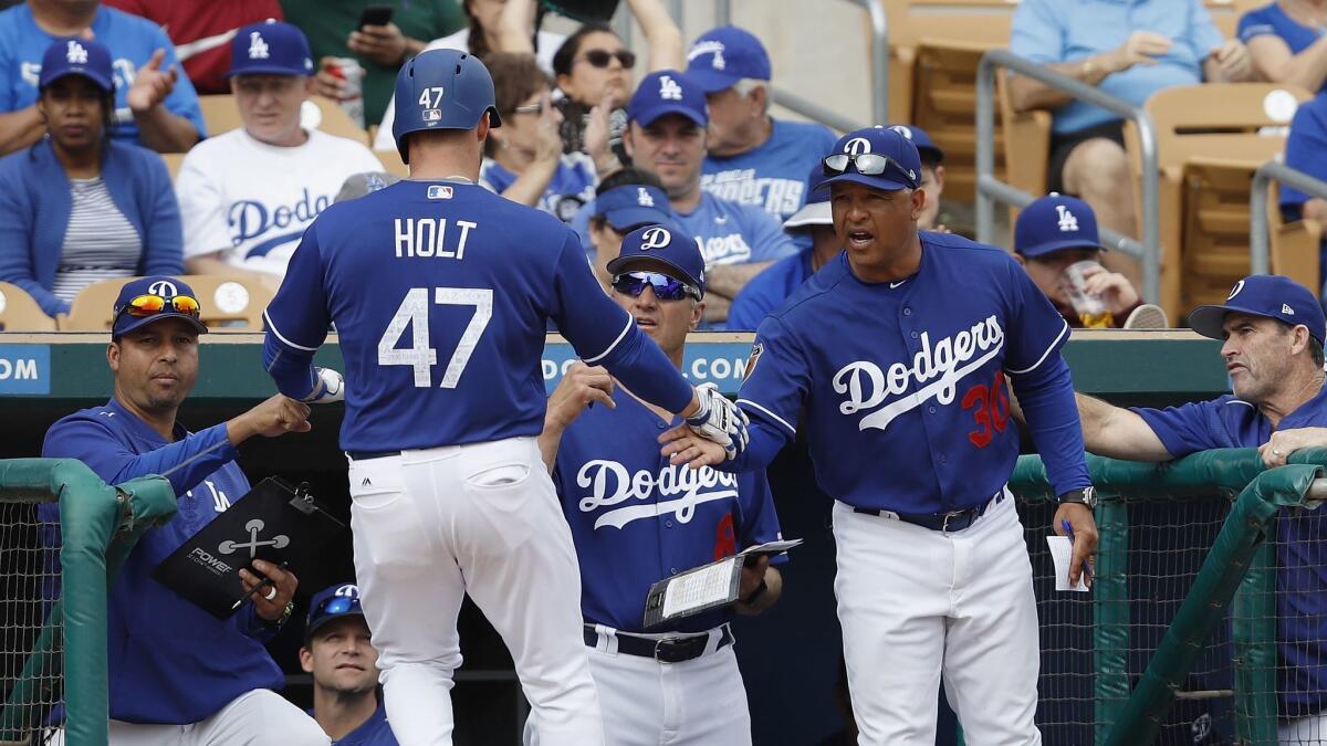 Dodgers Manager Dave Roberts congratulates Tyler Holt, who scored during a spring training game against Seattle on March 5.