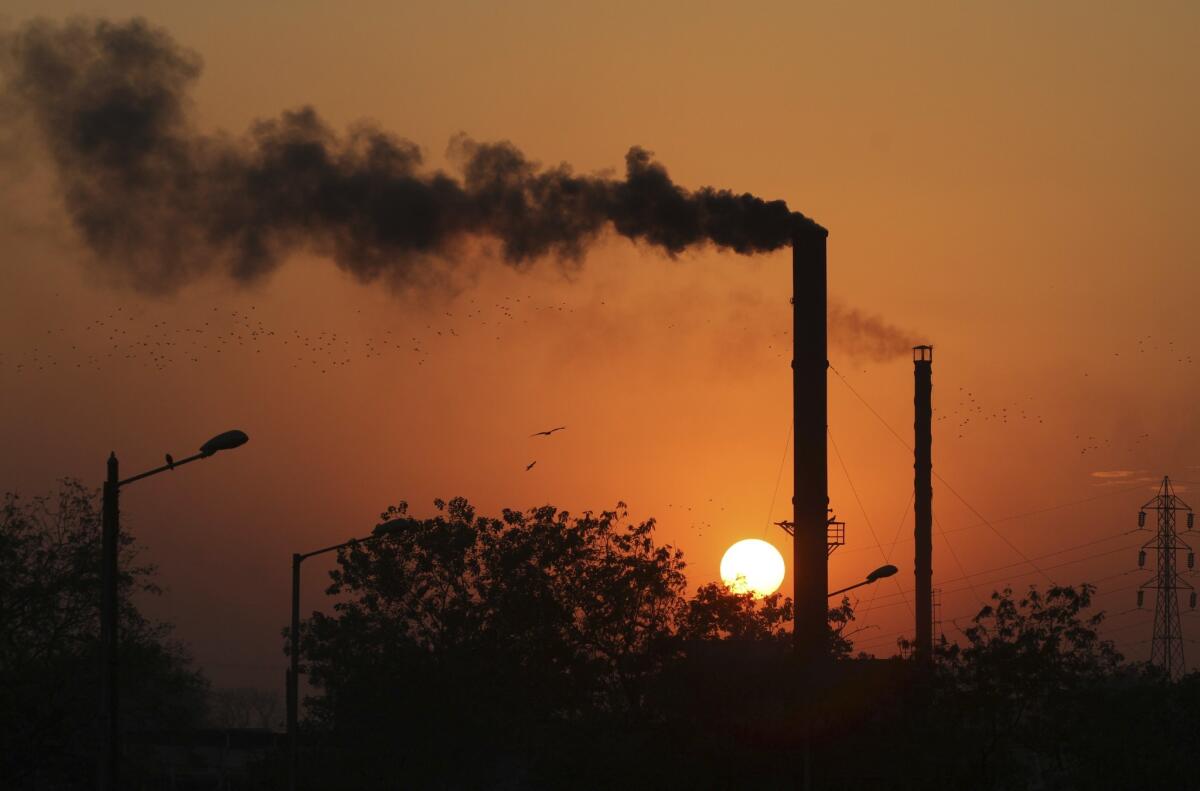 Smoke curls from a chimney at a factory in Ahmadabad, India.