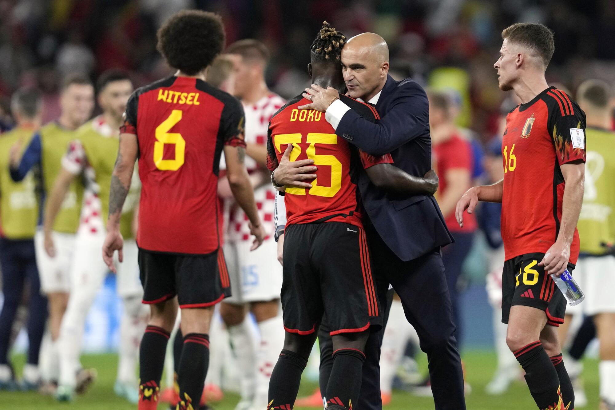 El técnico de Bélgica Roberto Martínez abraza a Jeremy Doku 