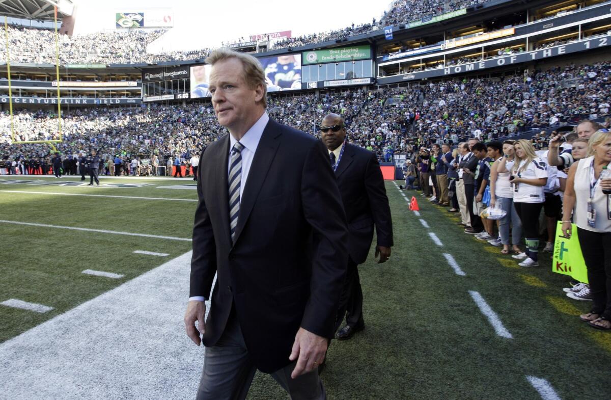 NFL Commissioner Roger Goodell walks on the field Thursday before the Packers-Seahawks game. The NFL Players Assn. says the league asked for the right to immediately suspend players who are arrested for allegedly driving under the influence.