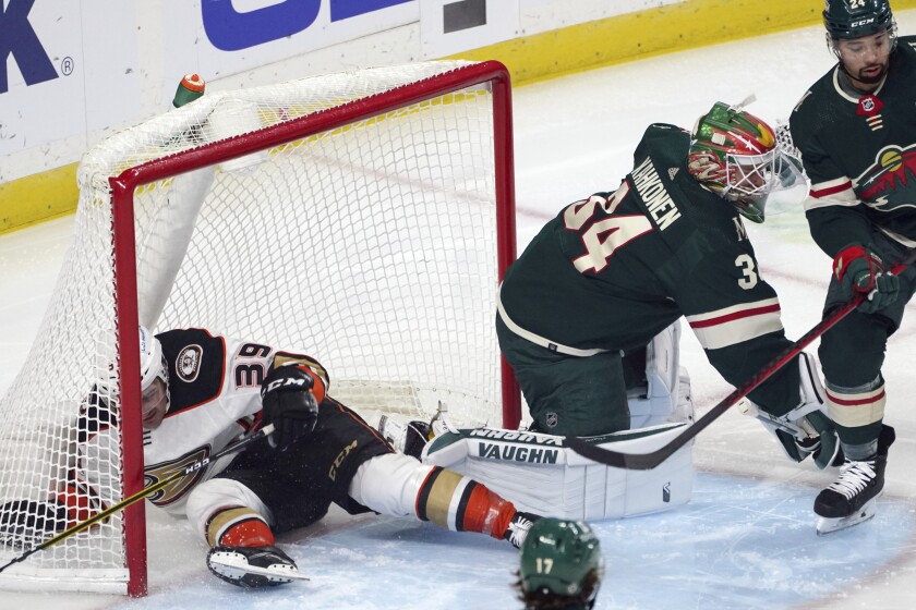 The Ducks' Sam Carrick winds up in the net as Wild goalie Kaapo Kahkonen follows the action in the first period.