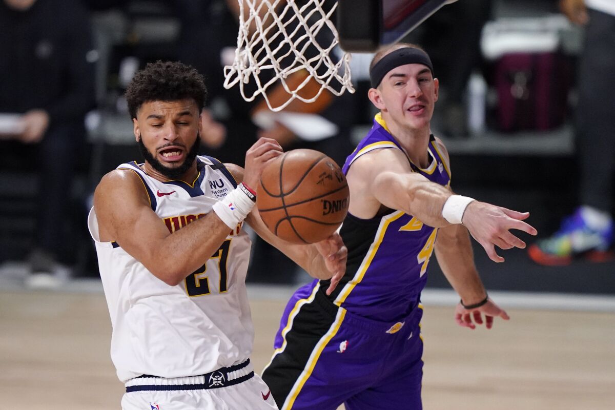 Lakers guard Alex Caruso blocks a layup by Nuggets star Jamal Murray.