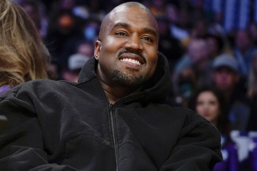 FILE - Kanye West, known as Ye, watches the first half of an NBA basketball game between the Washington Wizards and the Los Angeles Lakers, March 11, 2022, in Los Angeles. Adidas CEO Bjørn Gulden said on a recent podcast that he didn't believe that Ye “meant what he said” when he made a series of antisemitic remarks in 2022. (AP Photo/Ashley Landis, File)