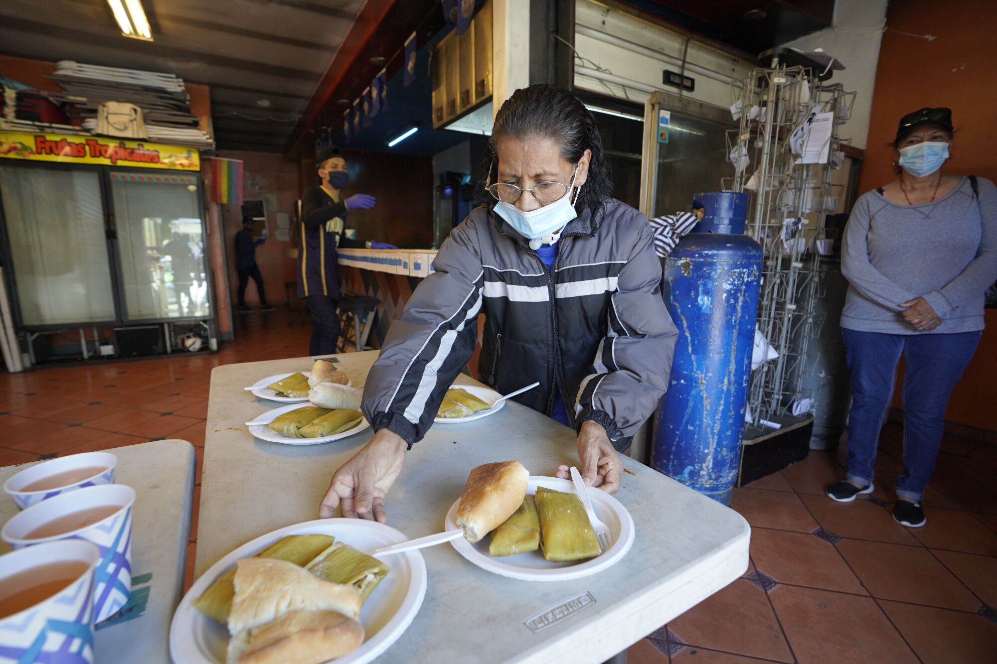 Esther Morales prepares plates of food to hand out at a soup kitchen in Tijuana.