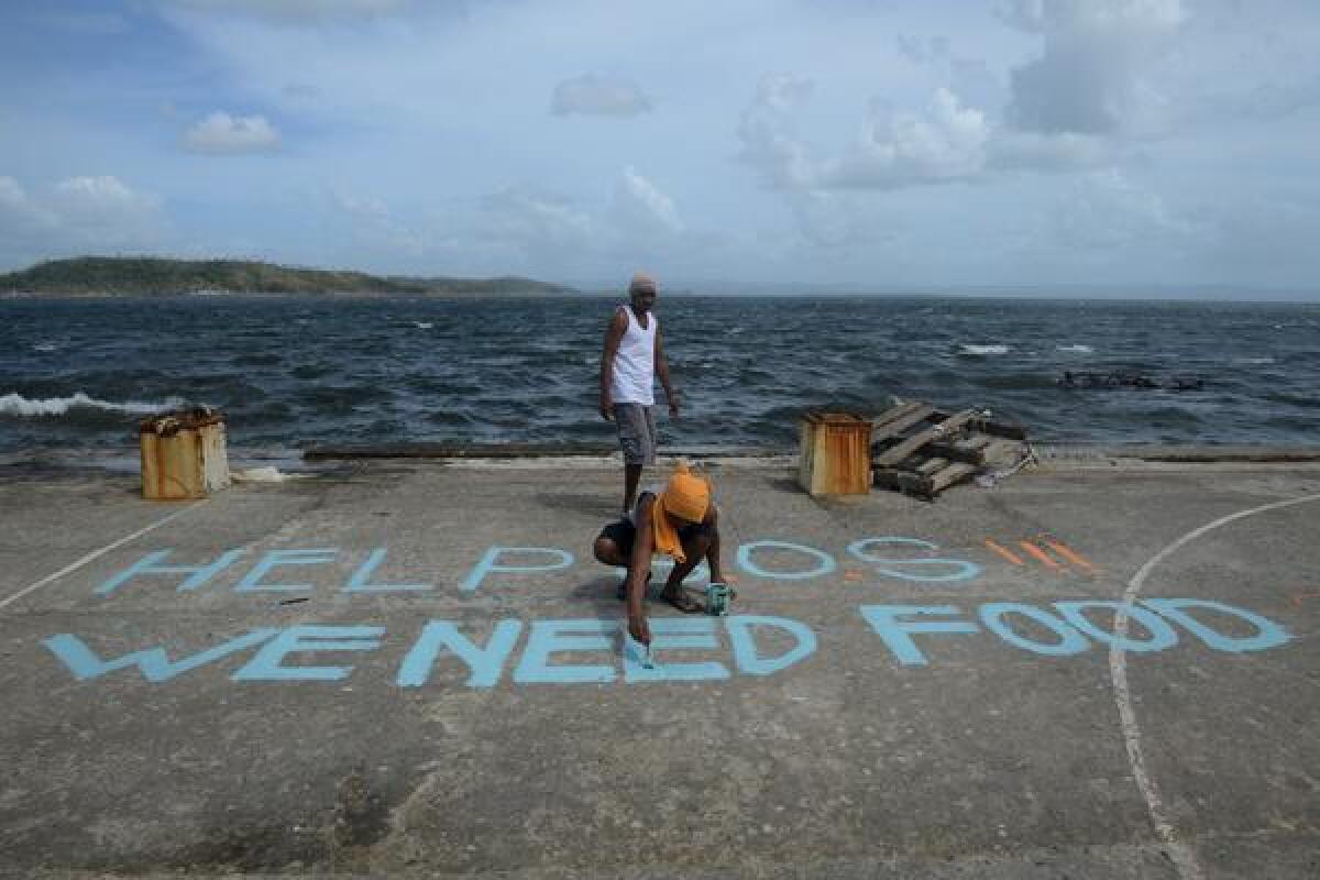 A man paints a distress message on a basketball court in Tacloban, on the Philippine island of Leyte.