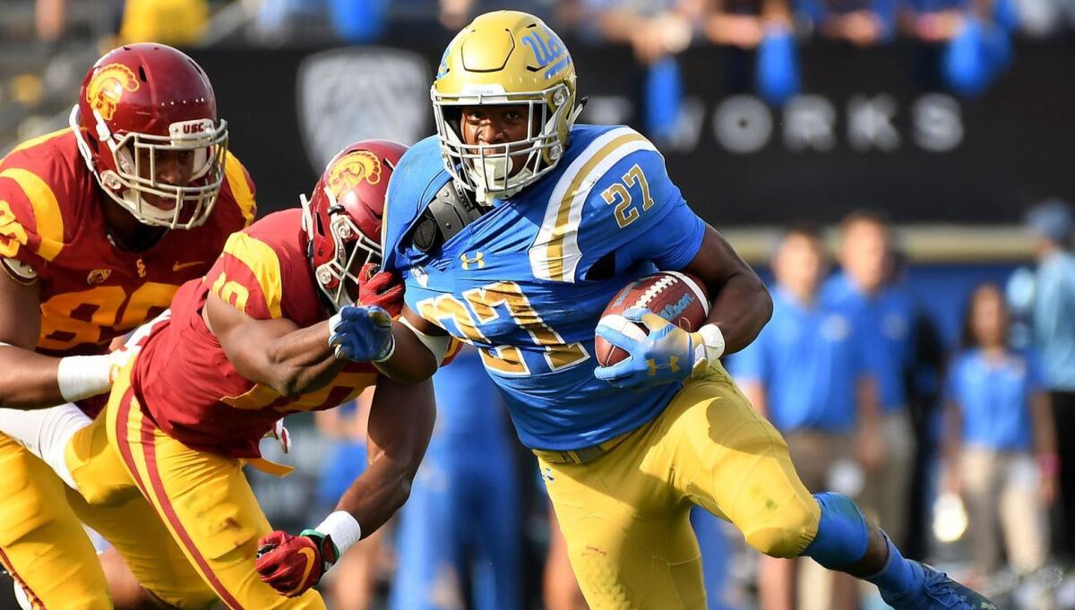 UCLA running Joshua Kelley picks up yards during last year's game against USC. Kelley and his teammates are using chess to help improve their game.