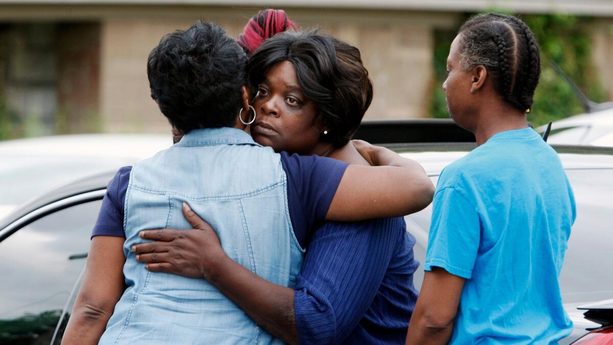 Pastor Mary Moore, left, hugs a woman outside a home where a fire killed nine people in Memphis, Tenn., on Sept. 12.