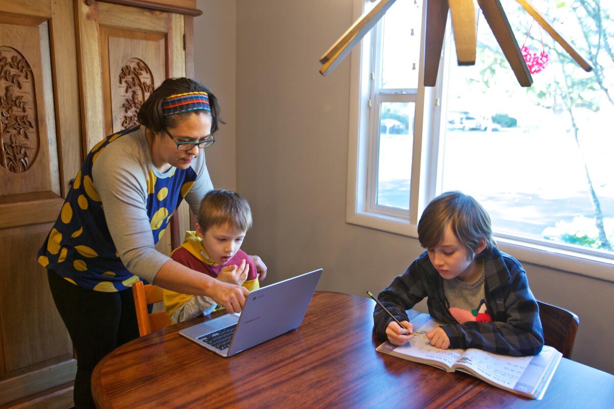 Olivia Bucks durante las horas de escuela en casa junto con sus hijos Keith Bucks y Ashton Morris, en Beaverton, Oregon, el 17 de marzo de 2020. (AP Foto/Craig Mitchelldyer)