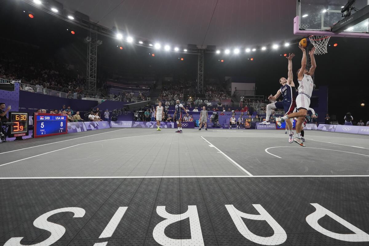 Mihailo Vasic of Serbia jumps to score against Jimmer Fredette of the U.S. in men's 3-on-3 basketball.