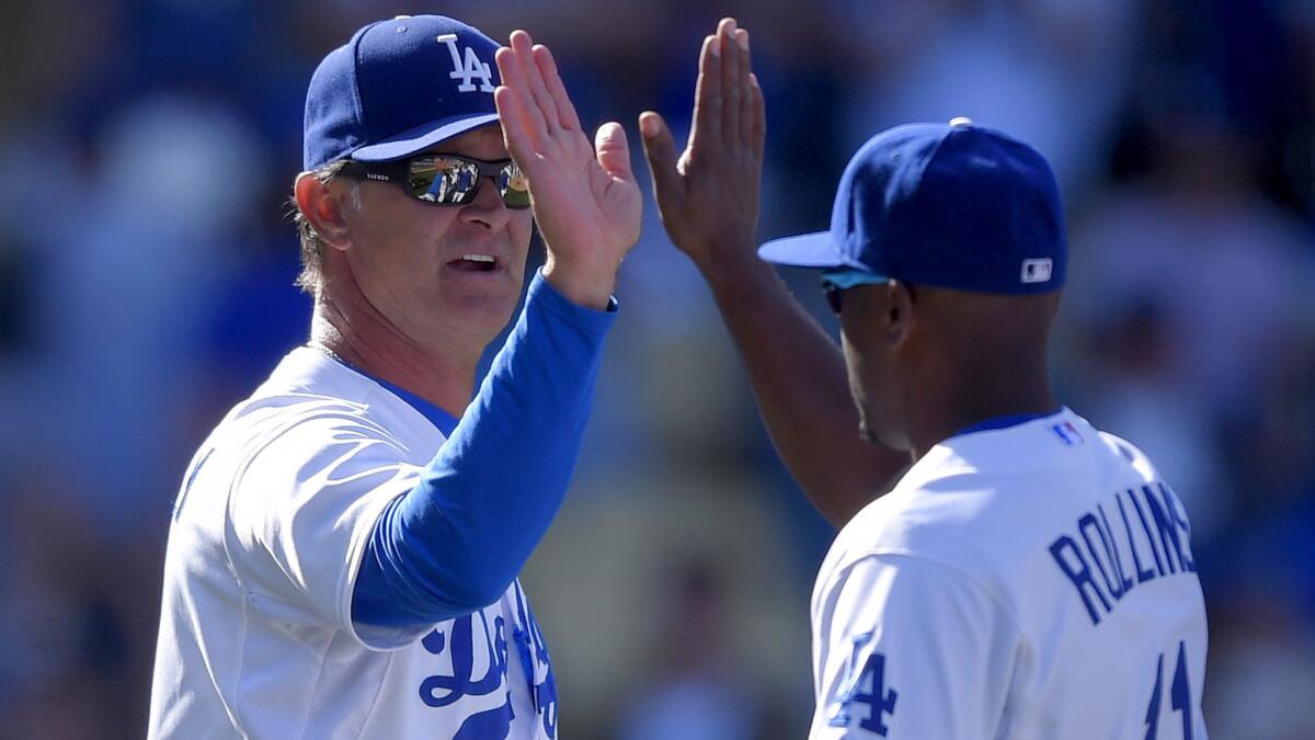 Manager Don Mattingly congratulates shortstop Jimmy Rollins after the Dodgers defeated the Padres on opening day.