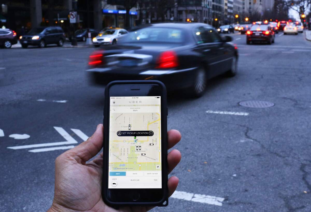 Who gets the benefit?This file photo shows the Uber smartphone app, being used by a passenger in Washington, D.C.