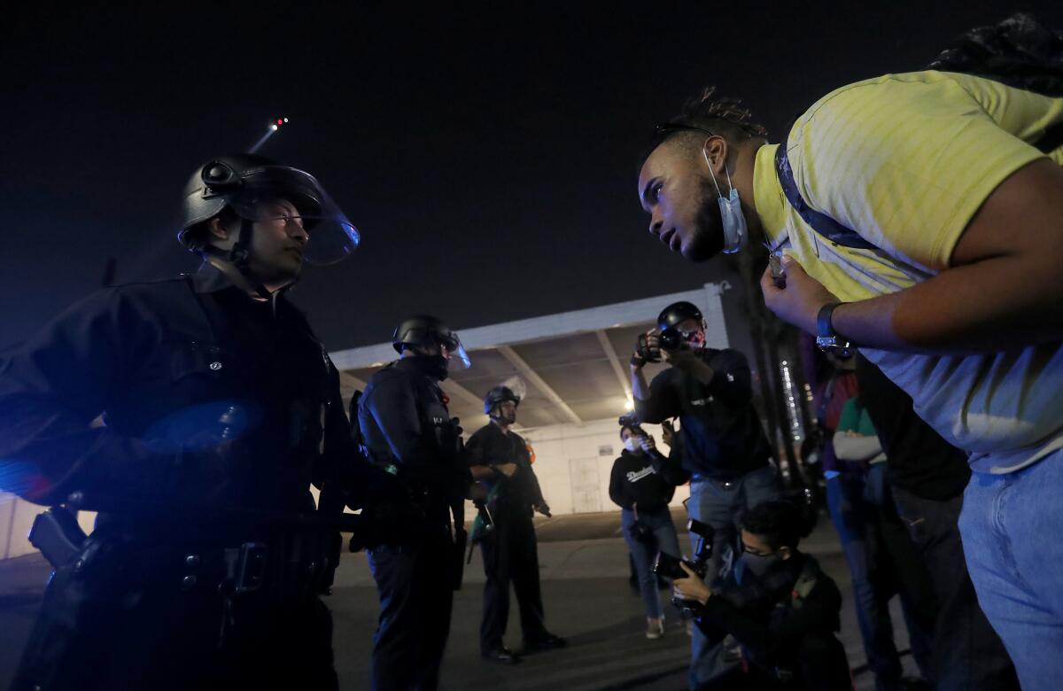 A protester confronts an LAPD officer in downtown Los Angeles on election night.