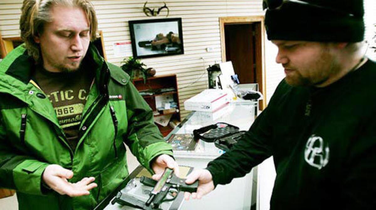 Eric Thompson shows a handgun to customer Nicholas Koch in his Green Bay, Wis., showroom. Koch, a regular customer and former Marine who has six or seven handguns at home, says he resents the blame Thompson receives for his customers' crimes: Its like Chevy getting blamed for people driving drunk.
