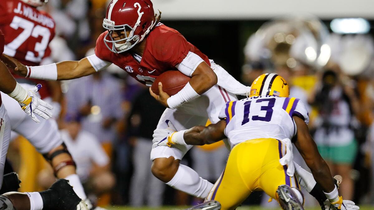Alabama quarterback Jalen Hurts attempts to break a tackle by LSU's Dwayne Thomas during their SEC game Saturday.